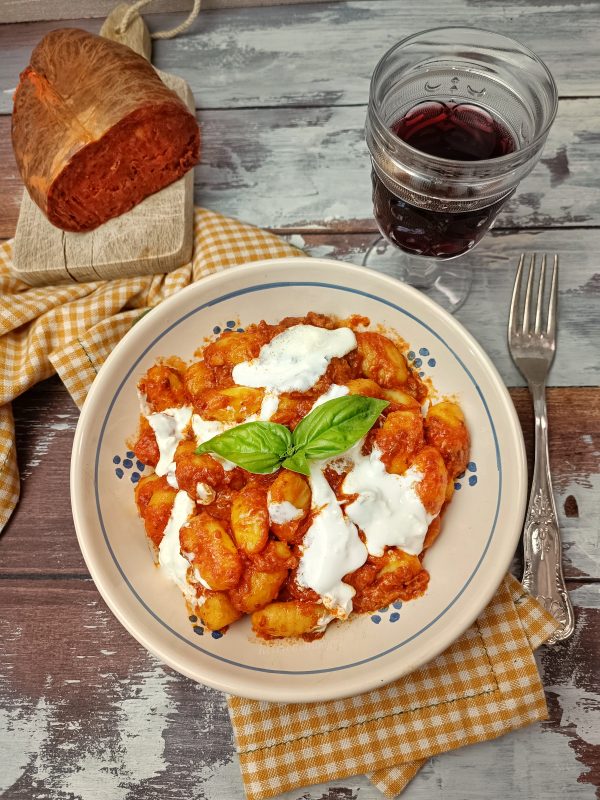 Serviamo  gli gnocchi di patate nei piatti da portata,  aggiungiamo qualche ciuffetto di stracciatella e basilico fresco.